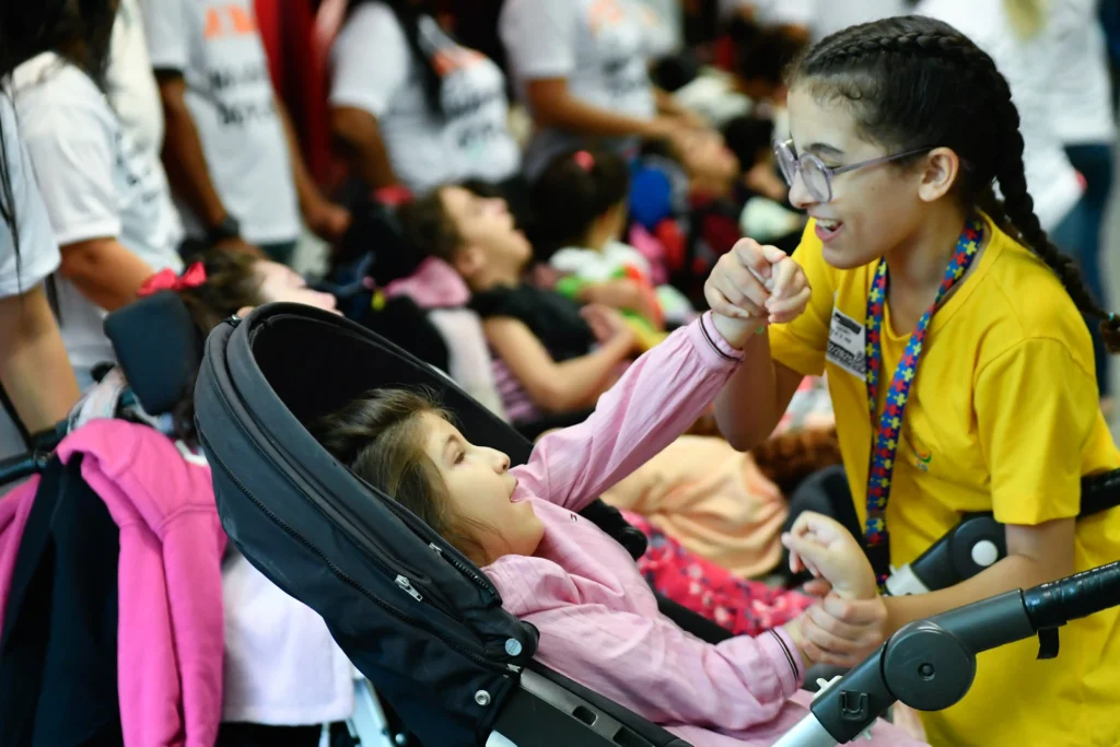 Criança em cadeira adaptada durante manifestação de familiares em defesa da pensão especial para pessoas com sequelas associadas ao Zika vírus.